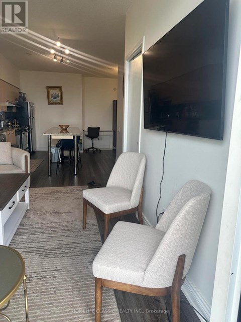 Two chairs are placed in a living room with a television mounted on the wall.