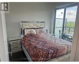 A bedroom with a large bed and a view of the city.