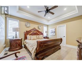 A bedroom with a large bed and a ceiling fan.