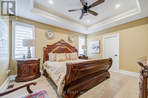 A bedroom with a large bed and a ceiling fan.
