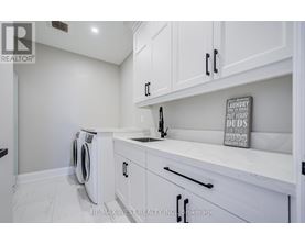 A laundry sign is on the counter in a white kitchen.
