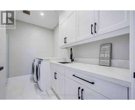A laundry sign is on the counter in a white kitchen.