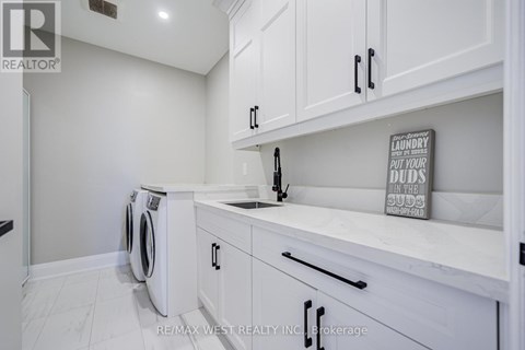 A laundry sign is on the counter in a white kitchen.