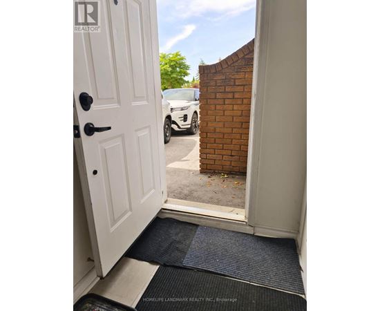 A doorway with a mat on the floor leading to a driveway.