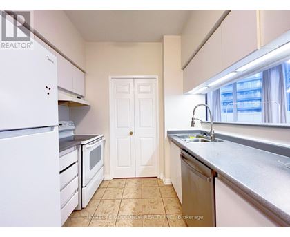 A small, clean kitchen with white appliances and a tiled floor.