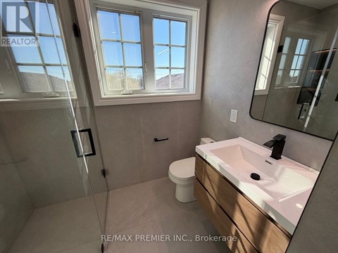 A bathroom with a sink, mirror, and a window.