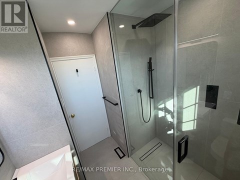 A bathroom with a walk-in shower and a white door.