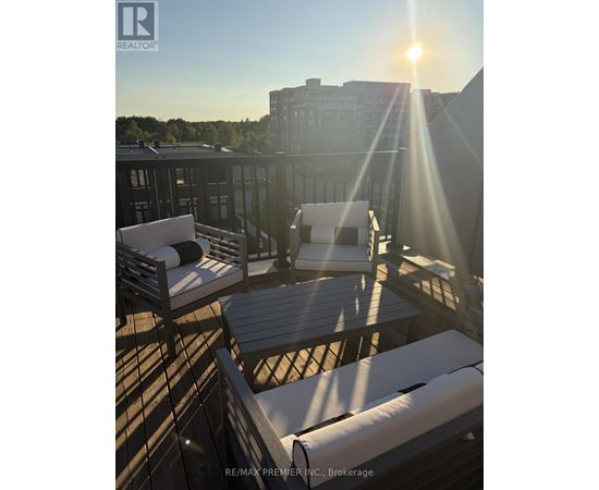 A sunny day on the rooftop of a building with chairs and a table.