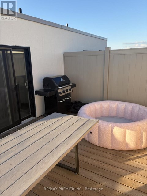 A backyard with a hot tub and a grill.