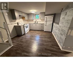 A kitchen with wooden floors and white appliances.