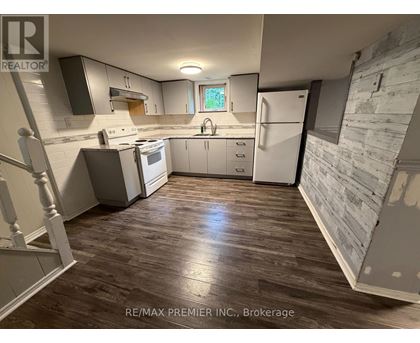 A kitchen with wooden floors and white appliances.