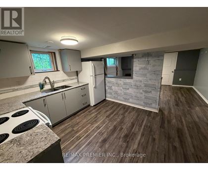 A kitchen with a stove top oven and a refrigerator.
