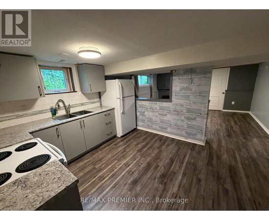 A kitchen with a stove top oven and a refrigerator.