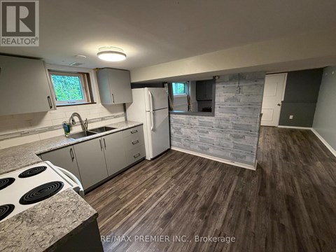A kitchen with a stove top oven and a refrigerator.