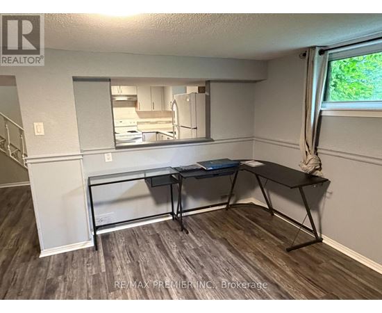 A room with a desk and a mirror on the wall.