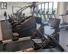 A gym with treadmills and a woman walking by.
