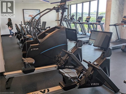 A gym with treadmills and a woman walking by.