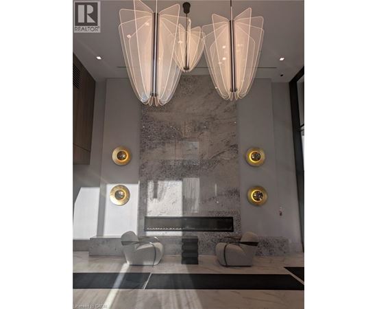 A modern living room with a marble wall and a large chandelier.