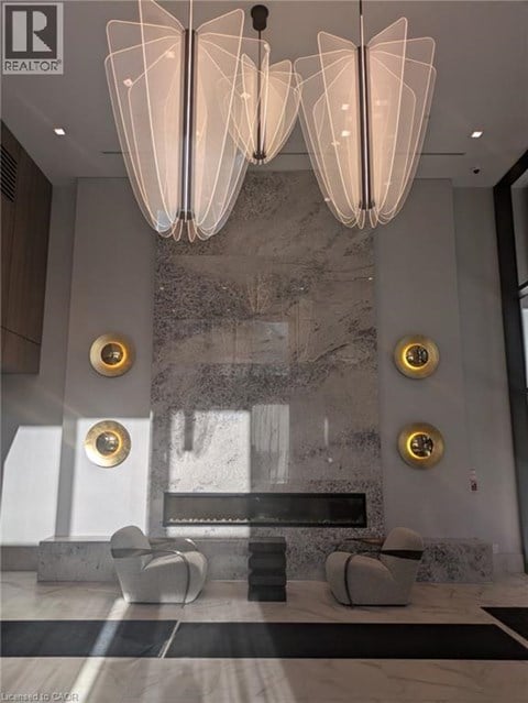 A modern living room with a marble wall and a large chandelier.