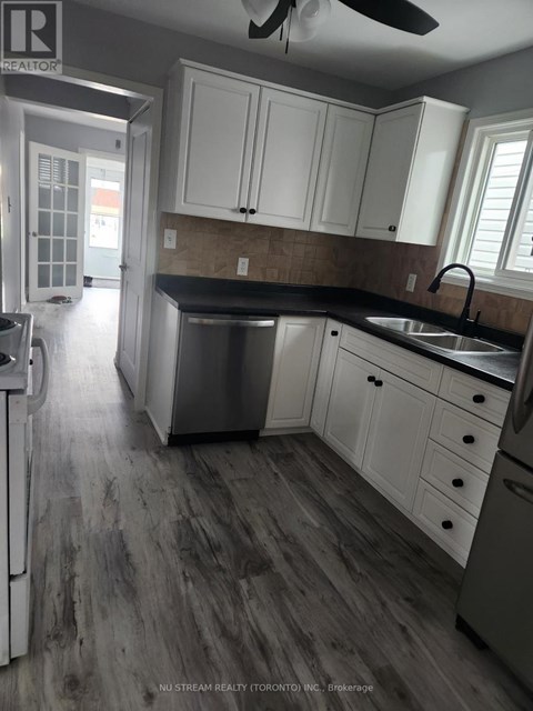 A kitchen with white cabinets and a black countertop.