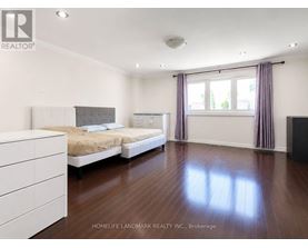 A bedroom with a large bed and a dresser.
