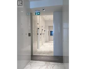 A hallway with a green exit sign above the door.