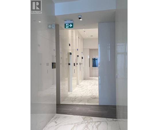 A hallway with a green exit sign above the door.