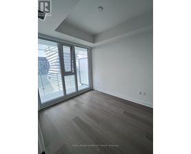 A room with a sliding glass door and wooden flooring.
