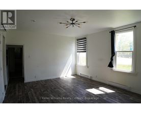 A room with a ceiling fan and a window with blinds.