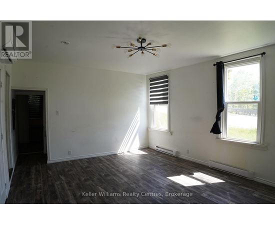 A room with a ceiling fan and a window with blinds.