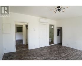 A room with a ceiling fan and wood flooring.