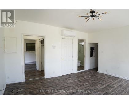 A room with a ceiling fan and wood flooring.