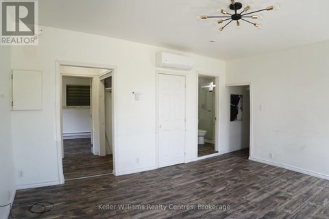 A room with a ceiling fan and wood flooring.