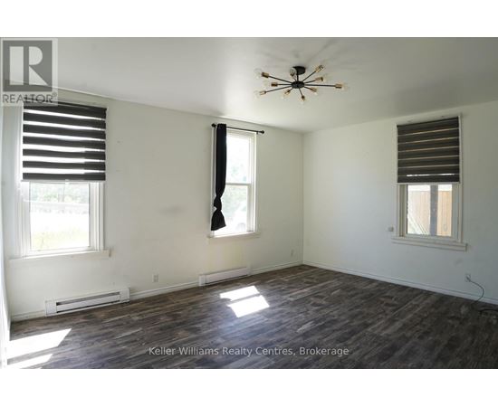 A room with a ceiling fan and two windows.