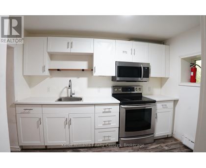 A kitchen with white cabinets and a black stove top oven.