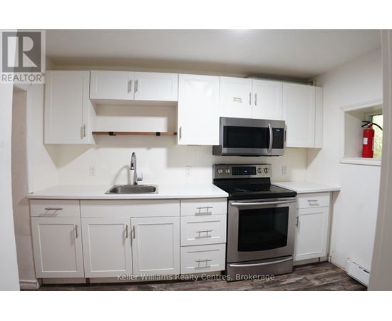 A kitchen with white cabinets and a black stove top oven.