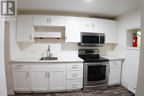 A kitchen with white cabinets and a black stove top oven.