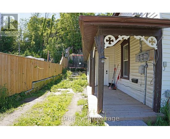 A wooden fence and a porch with a cross design on it.