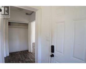A white door with a black handle is in a room with white walls.