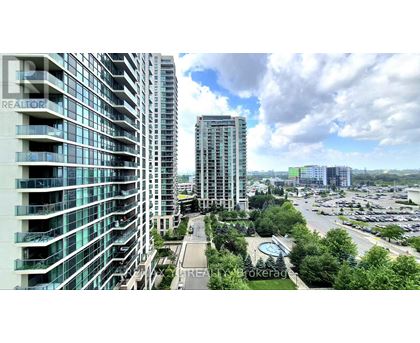 A view of a cityscape with a large building in the foreground and a parking lot in the background.