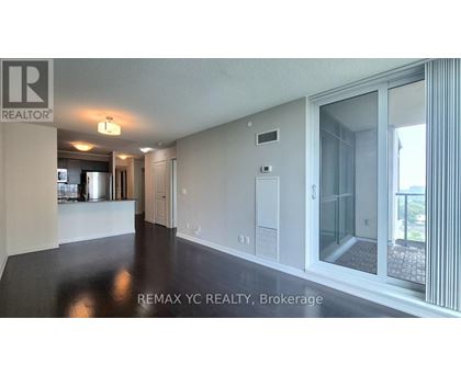 A spacious room with a sliding glass door leading to a balcony.