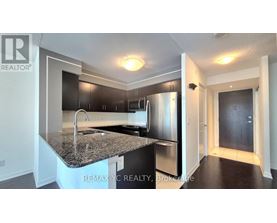 A kitchen with a granite countertop and stainless steel appliances.