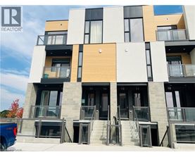 A modern multi-story building with balconies and doors numbered from 10 to 14.
