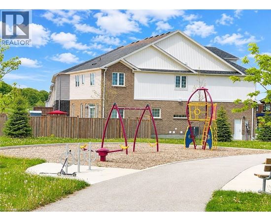 A playground with a swing set and a slide in front of a house.
