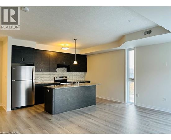 A modern kitchen with a refrigerator, stove, and island.