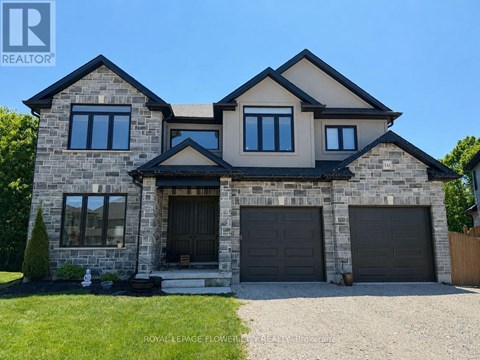 A large house with a stone facade and two garages.