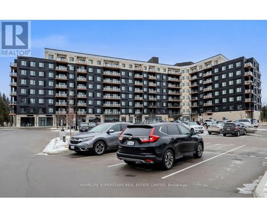 A black and white apartment building with cars parked in front.