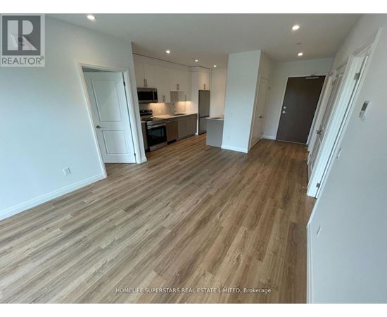 A spacious living room with wooden flooring and white walls.