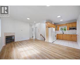 A large open living room with wood floors and a fireplace.