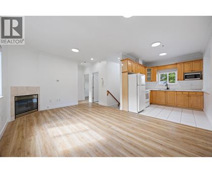 A large open living room with wood floors and a fireplace.